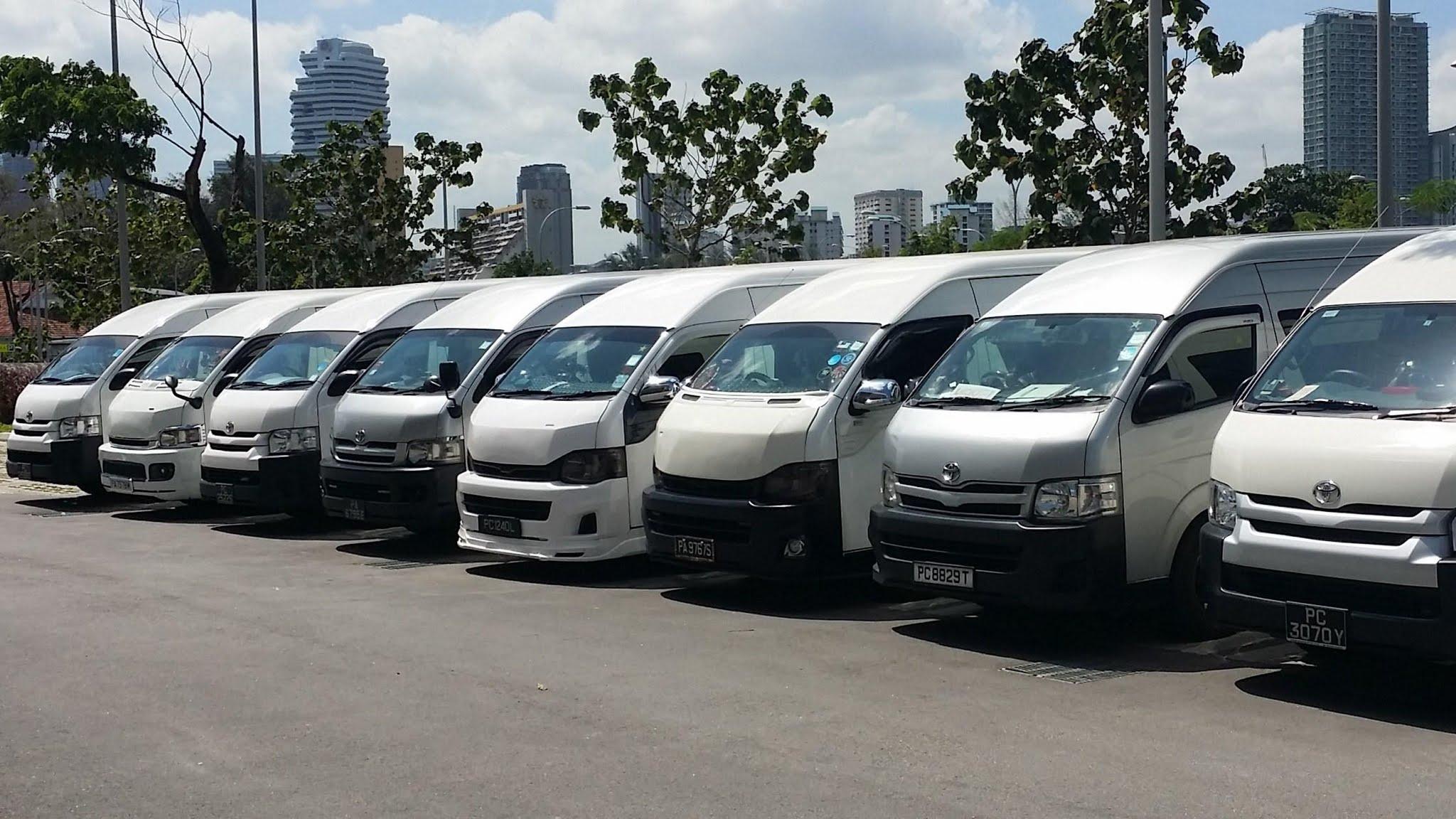A white Toyota Hiace minibus on a road.